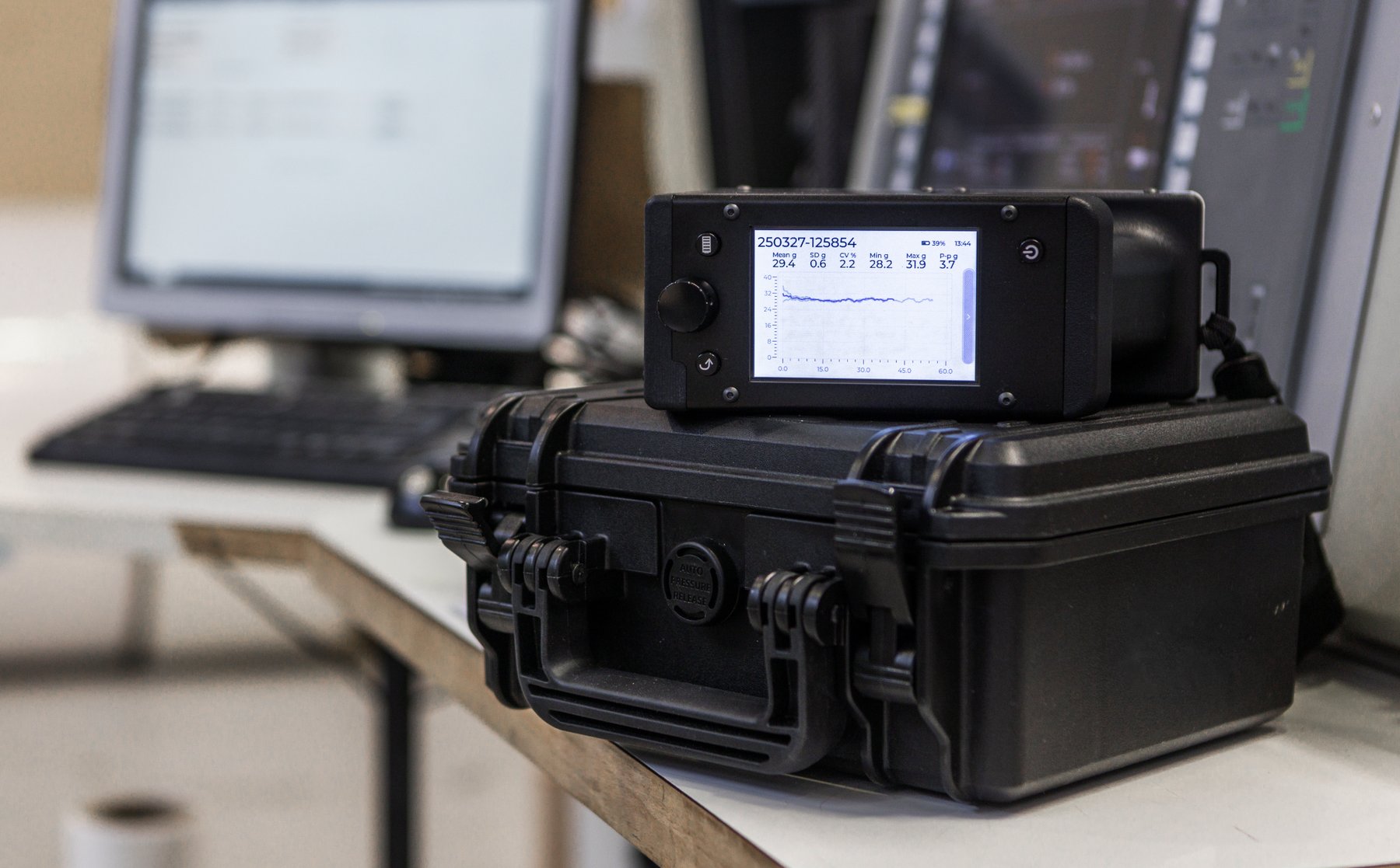 Tapio RQP Live device with a graphical display showing a roll hardness profile, placed on a black protective case in an industrial environment.
