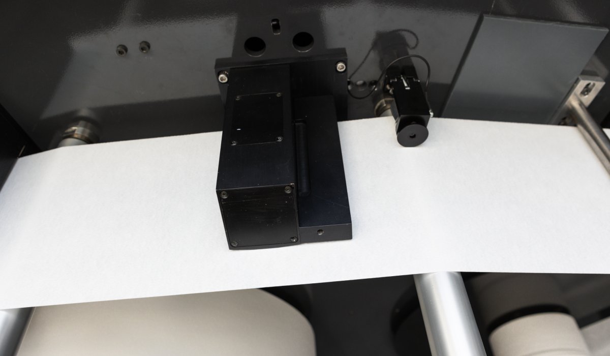 Tapio Gloss Sensor measuring gloss on both sides of a paper sheet with a 75° angle.